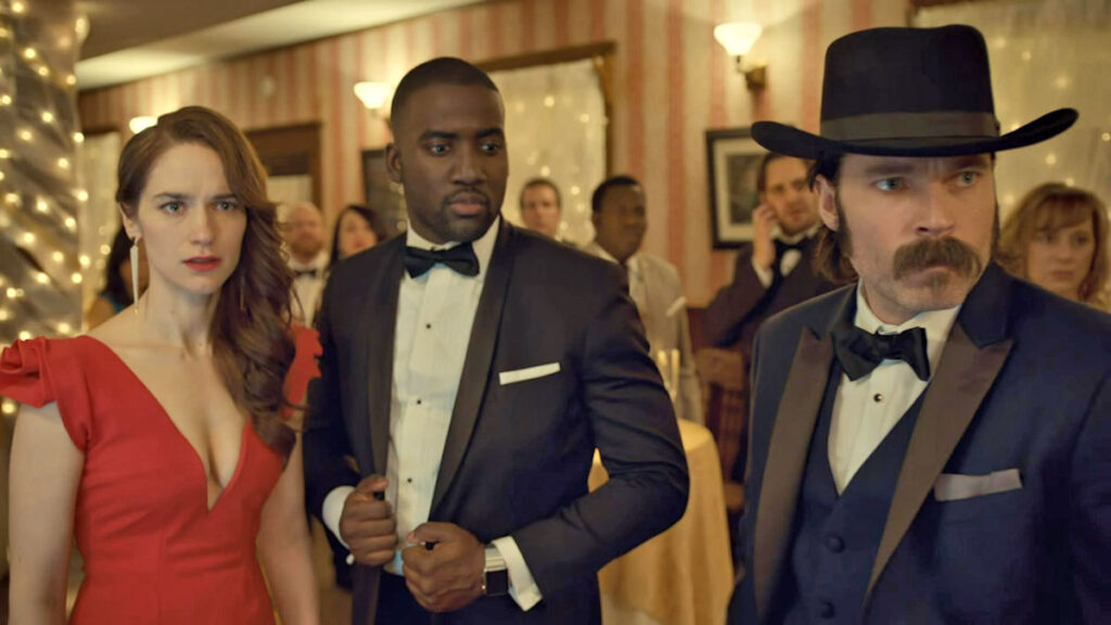 At Bobo's party - Melanie Scrofano as Wynonna, Shamier Anderson as Dolls, and Tim Rozon as Doc - Wynonna Earp