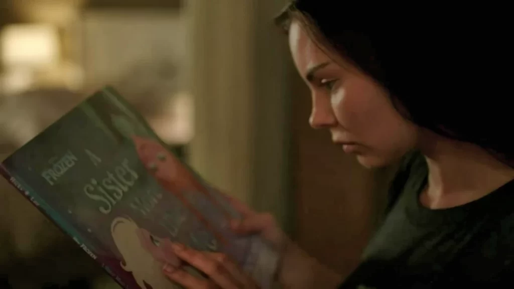 Ryn (Eline Powell) with the book 'Frozen: A Sister More Like Me'