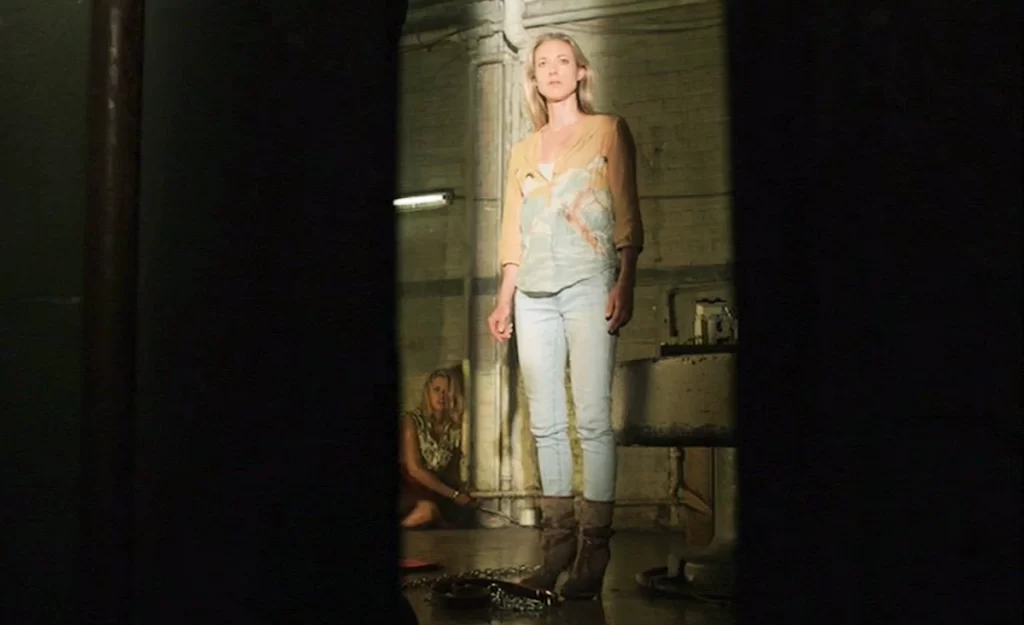 Dr. Lauren Lewis (Zoie Palmer) in a dungeon with Crystal (Ali Liebert) chained to a pipe behind - Lost Girl 404