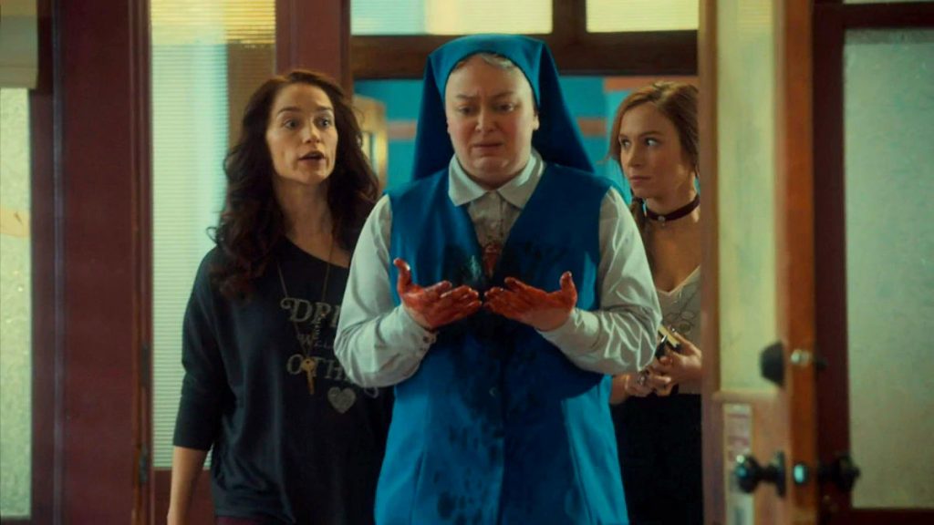 Wynonna (Melanie Scrofano) and Waverly (Dominique Provost-Chalkley) attend to the nun (Meg Farhall)