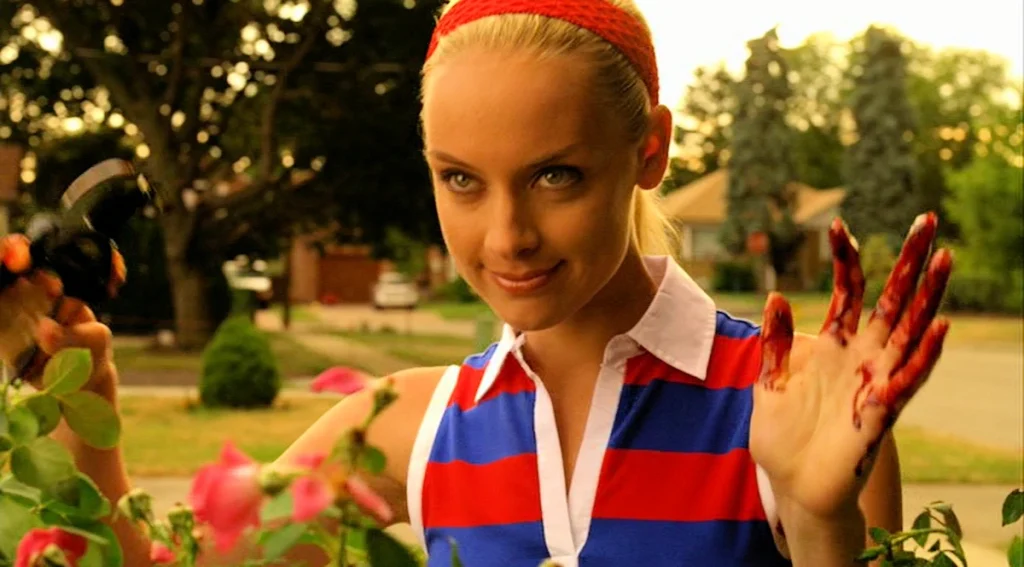 Tamsin (Rachel Skarsten) dressed in red, white, and blue, trims her hedge and greets her neighbour Bo - Lost Girl 309