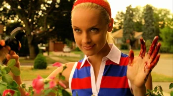Tamsin (Rachel Skarsten) dressed in red, white, and blue, trims her hedge and greets her neighbour Bo - Lost Girl 309